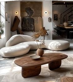 a living room filled with lots of furniture and art on the wall above it's coffee table