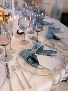 the table is set with silverware and blue napkins