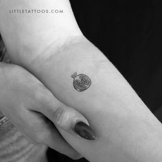 a small apple tattoo on the left inner arm and wrist, done by little tattoos