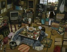 a room filled with lots of clutter next to a tv and table full of food