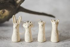 three small ceramic animals are standing next to each other