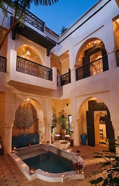 an indoor swimming pool in the middle of a house with arches and windows on both sides