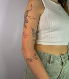 a woman with a tattoo on her left arm and the other arm behind her back