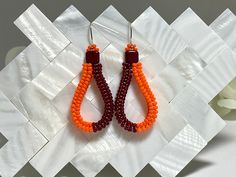 MAROON AND ORANGE HERRINGBONE EARRINGS These unique handmade beaded earrings are perfect school spirit earrings for game day or a graduation gift. ✦DETAILS: 11/0 seed beads are handwoven in a herringbone stitch and formed into a teardrop shape. They hang from silver plated (nickel free) earwires. Measures approximately 3/4 inch wide with a 1 3/4 inch drop from top of ear wire to bottom of earring. ✦ALL ITEMS ARE HANDMADE BY ME IN LEESBURG, VA *USA* 🇺🇸..THANK YOU FOR VISITING AND SUPPORTING SMALL BUSINESSES✦ ✦See more beautiful Sunset SouthPaw designs here: https://www.etsy.com/shop/SunsetSouthPaw ✦Photos are purposely taken up close to show the detail of my work. Please take note of dimensions, some pieces may appear larger in the photo than in real life. Please message me with any quest Orange Shirt Beaded Earrings, Handwoven Orange Beaded Earrings As Gift, Orange Teardrop Beaded Earrings For Gift, Orange Handwoven Beaded Earrings, Artisan Orange Handwoven Earrings, Herringbone Stitch, Virginia Tech, Handmade Earrings Beaded, Herringbone