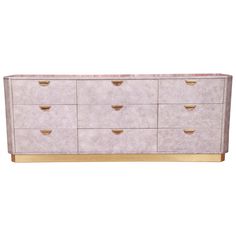 a white dresser with gold handles and drawers on the bottom, against a white background