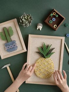 two framed pictures with pineapples and succulents in them on a table