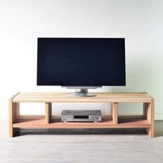 a flat screen tv sitting on top of a wooden stand in front of a white wall