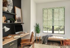 a bedroom with a bed, desk and computer on the table in front of a window