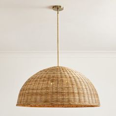 a wicker light fixture hanging from the ceiling in a room with white walls and flooring