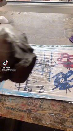 a person is painting graffiti on a piece of paper