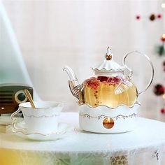 a tea pot and cup sitting on top of a table