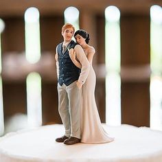 a bride and groom figurine on top of a cake