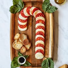 a wooden cutting board topped with slices of bread and sliced tomatoes