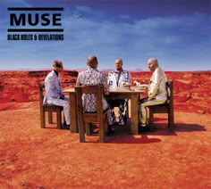 three men sitting at a table in the middle of a red desert with blue sky