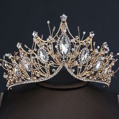 a gold tiara with white and clear stones on it's headpieces