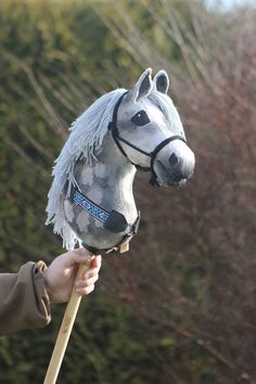 a person holding a horse head on top of a stick