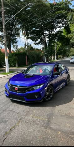 a blue car is parked on the street