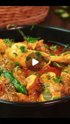 a bowl filled with chicken curry and garnished with parsley on the side