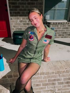 a woman in an air force uniform is posing on the steps with her legs crossed