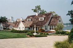 a white house with brown shingles on the roof