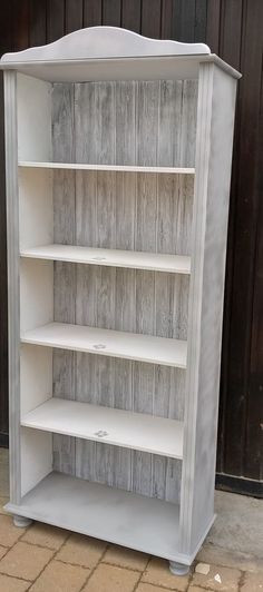 a white bookcase with wooden shelves on the outside