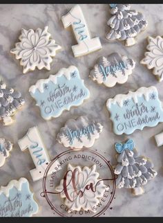 cookies decorated with frosting and icing are arranged on a marble countertop for christmas