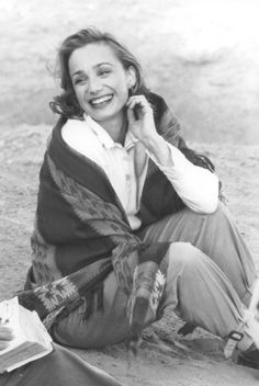 a woman sitting on the ground talking on her cell phone