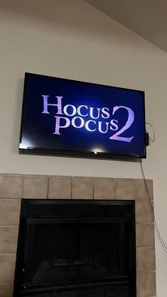 a large television mounted to the side of a wall above a fireplace