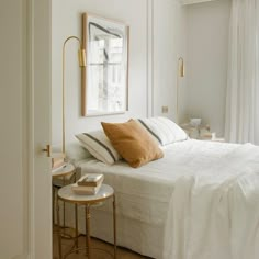 a bedroom with white walls and wood floors