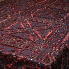 a red and black bedspread with an intricate design