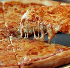 a close up of a slice of pizza on a pan with one piece being taken out