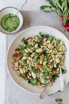 a white bowl filled with salad next to another bowl