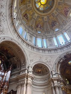 the interior of an ornate church with high ceilings and stained glass windows on each side