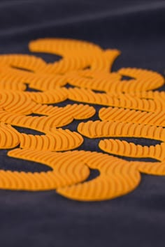 an orange and black design is shown on the ground with yellow circles in front of it