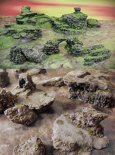 some rocks and grass in the middle of a desert area with an orange sky behind them