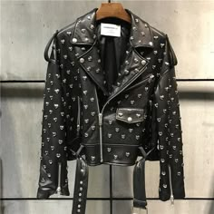 Heavy duty, black, soft genuine leather biker motorcycle style jacket with silver heart stud rivets all over. Features a zip-up collar, front zip pockets, and zippers on sleeve wrists. Poly satin lined with a belted waist for a relaxed, boxy fit. Perfect for adding an edgy touch to any outfit. Pair with jeans and boots for a classic biker look or layer over a dress for a chic, rebellious twist. Sizes by waist in inches. Painting Denim, Jackets Hoodie, Kate Moss Street Style, Leather Jacket Fashion, Botas Cowboy, Womens Biker Jacket, Embellished Jacket, Leather Jacket Style, Black Tweed