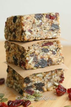 three granola bars stacked on top of each other with cranberries and sunflower seeds