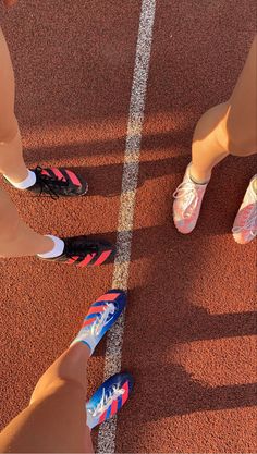 three people standing on a tennis court with their feet in the air and wearing colorful shoes