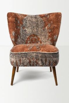 an upholstered chair with orange and grey fabric