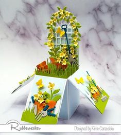 an origami house with flowers and gardening tools