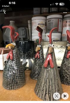 three ceramic roosters sitting on top of a counter