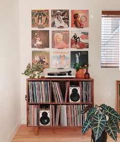 a record player is sitting on top of a shelf in front of a wall full of records