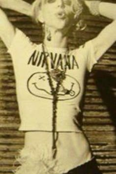 an old photo of a woman with her hands behind her head and wearing a hula skirt