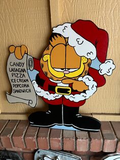 a cardboard cutout of garfield the cat holding a sign that says candy pizza and popcorn sandwich