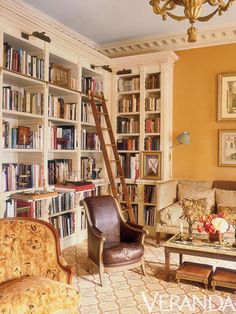 a living room filled with furniture and bookshelves covered in lots of bookcases