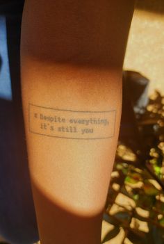 a person with a tattoo on their leg that says, despite everything else is still there