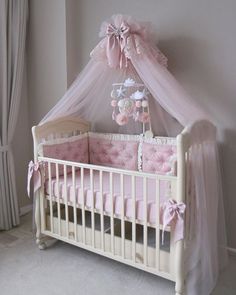 a baby crib with pink and white decor