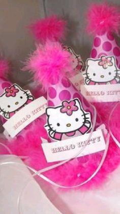 hello kitty party hats with name tags and pink fluffy pom - poms on them