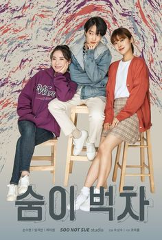 three women sitting on stools in front of a colorful background