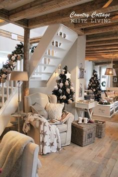 a living room filled with furniture next to a stair case covered in christmas tree decorations